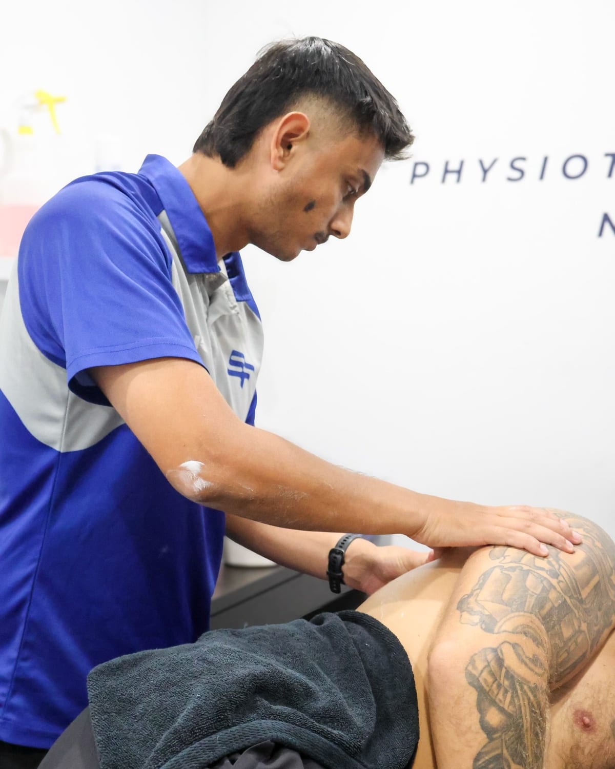 Physiotherapist applying soft tissue work along a patient shoulder at SportsFit Five Dock